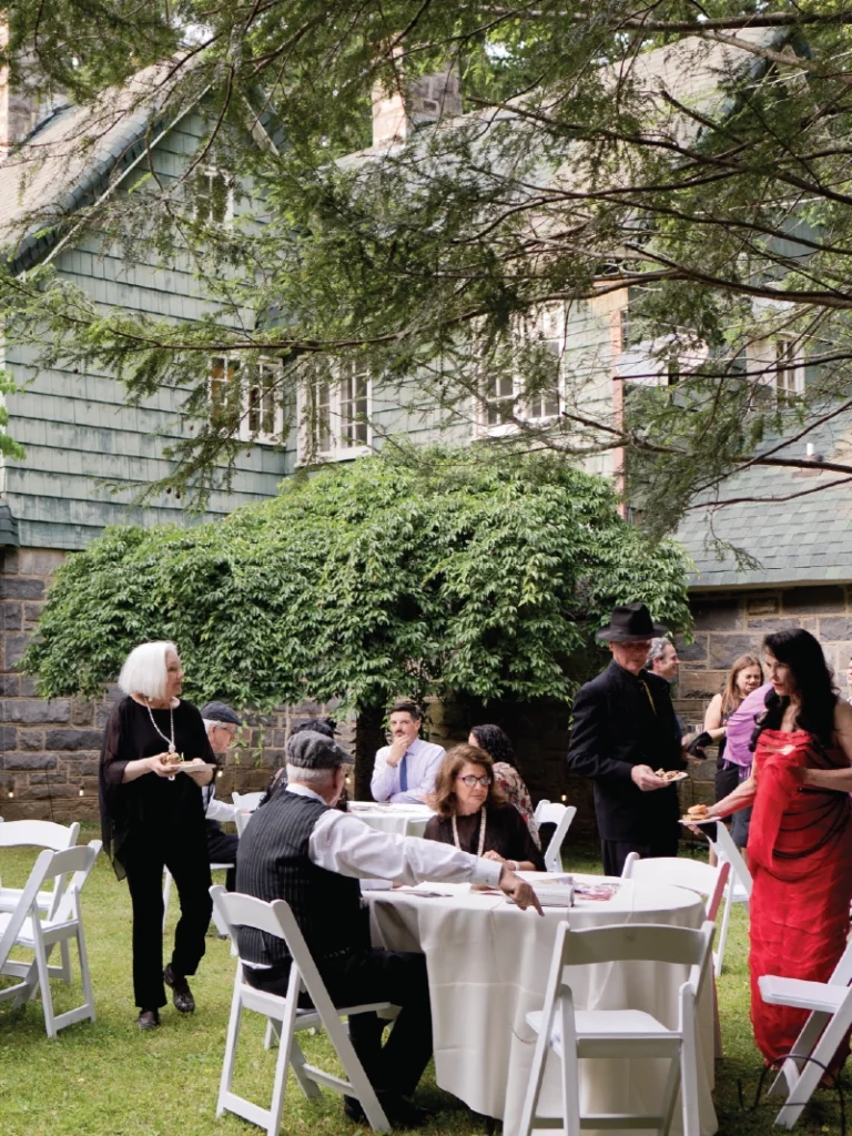 People in formal attire site at a table in the yard of IntheOaks